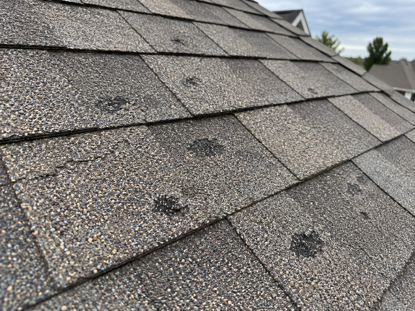 AI-generated illustration of hail damage on asphalt roof shingles.