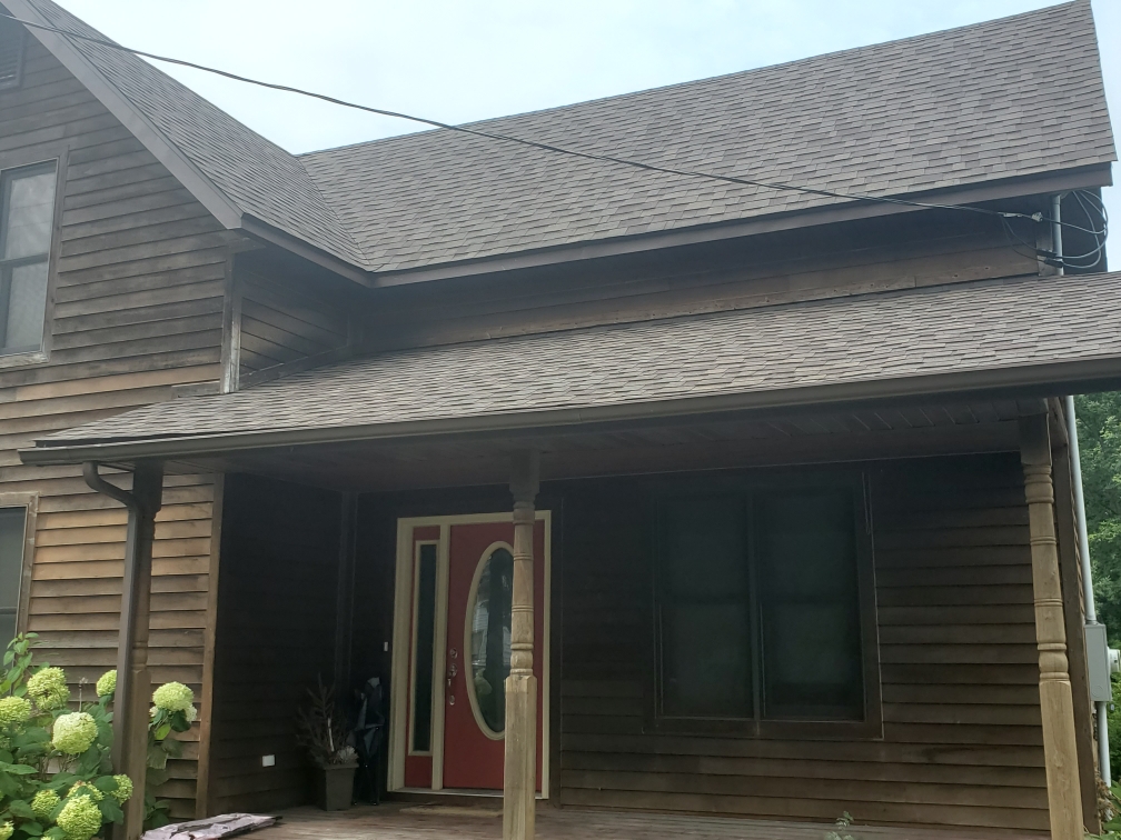 Finished shingle roof planes above a covered front porch