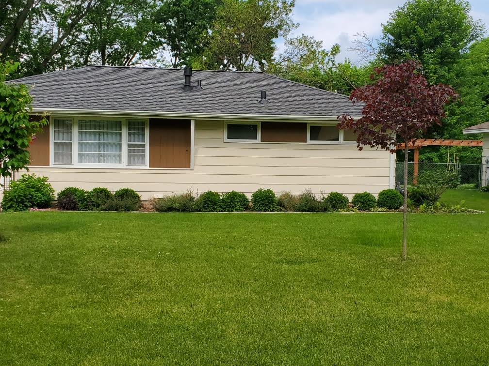 Finished gray shingle roof on a landscaped single-story home