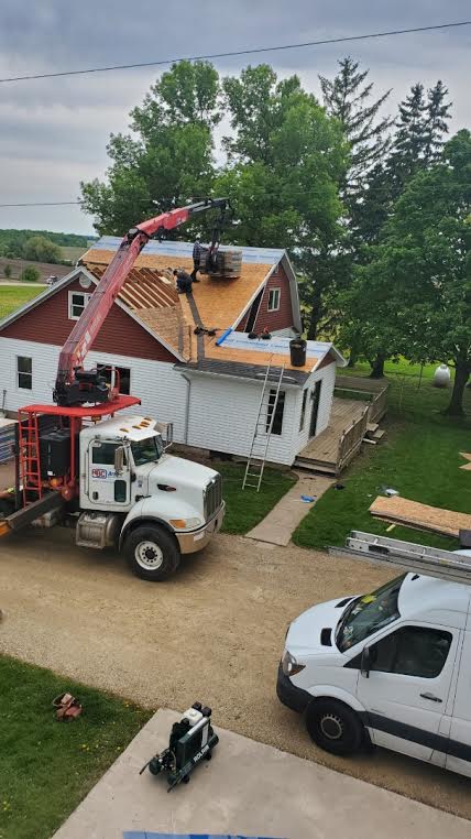 Level Edge crew working on a roof replacement with materials delivered by crane